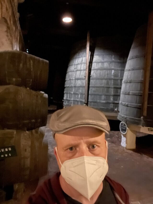 A selfie with me in my mask in front of giant wine casks at one of the Port wine cellars