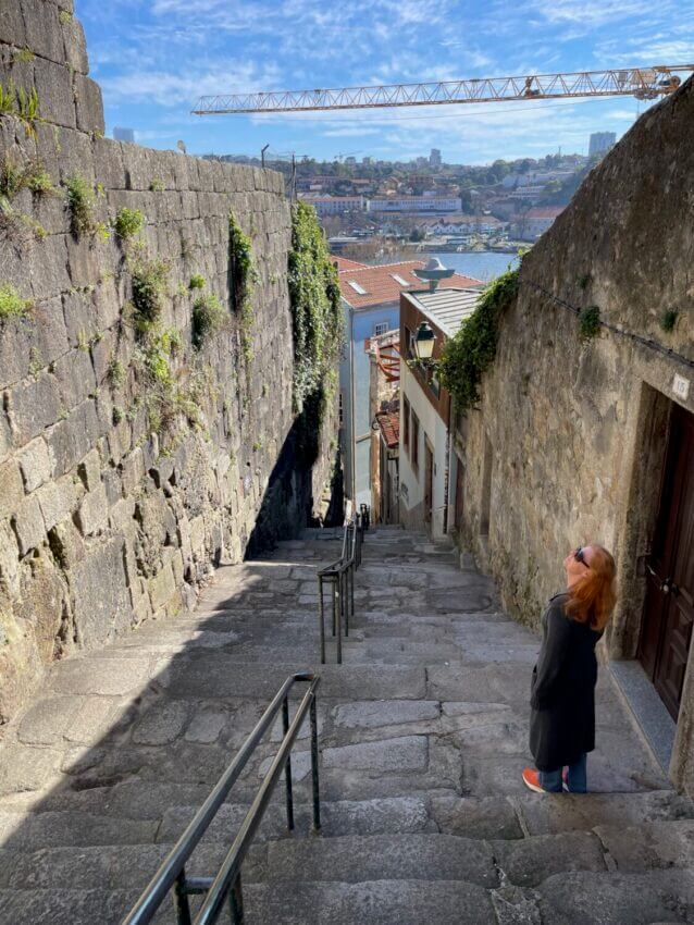 Looking down the stairs of a Porto "street" with the old city walls on the left and businesses and homes on the right.